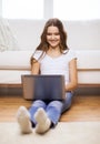 Smiling teenage girl with laptop computer at home Royalty Free Stock Photo