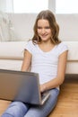 Smiling teenage girl with laptop computer at home Royalty Free Stock Photo