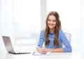 Smiling teenage girl laptop computer and notebook Royalty Free Stock Photo