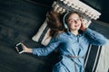 Smiling teenage girl with long hair lying at floor with pillow.Relaxing with cool music in headphone.Attractive student listening Royalty Free Stock Photo