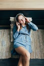 Smiling teenage girl with long hair lying at home interior and relaxing with cool music in headphone. Caucasian student listening Royalty Free Stock Photo