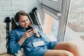 Smiling teenage girl with long hear lying at home interior and relaxing with cool music in headphone. Attractive student listening Royalty Free Stock Photo