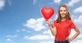 Smiling teenage girl with red heart shaped balloon Royalty Free Stock Photo