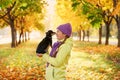 Smiling teenage girl relaxing with dog.girl playing with a small dog outdoors in autumn