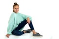 Smiling teenage girl sitting on floor. Isolated over white background. Royalty Free Stock Photo