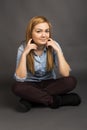 Smiling teenage girl sitting on the floor with legs crossed Royalty Free Stock Photo