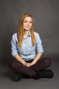 Smiling teenage girl sitting on the floor with legs crossed Royalty Free Stock Photo