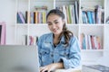 Smiling teenage girl studying with laptop in library Royalty Free Stock Photo