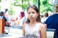 Smiling teenage girl in sunglasses in cafe on summer day Royalty Free Stock Photo