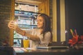 Smiling teenage girl taking a selfie on mobile phone in cafe Royalty Free Stock Photo