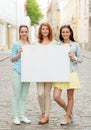 Smiling teenage girls with blank billboard Royalty Free Stock Photo