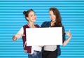 Smiling teenage girls holding white blank board Royalty Free Stock Photo