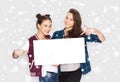 Smiling teenage girls holding white blank board Royalty Free Stock Photo