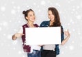 Smiling teenage girls holding white blank board Royalty Free Stock Photo