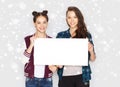 Smiling teenage girls holding white blank board Royalty Free Stock Photo