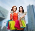 Smiling teenage girls with shopping bags and money Royalty Free Stock Photo