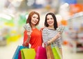 Smiling teenage girls with shopping bags and money Royalty Free Stock Photo