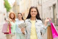 Smiling teenage girls with shopping bags on street Royalty Free Stock Photo