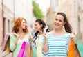 Smiling teenage girls with shopping bags on street Royalty Free Stock Photo