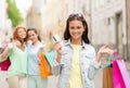 Smiling teenage girls with shopping bags on street Royalty Free Stock Photo