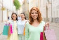 Smiling teenage girls with shopping bags on street Royalty Free Stock Photo