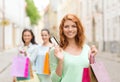 Smiling teenage girls with shopping bags on street Royalty Free Stock Photo