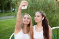 Smiling teenage girls taking self photo with cellular phone Royalty Free Stock Photo