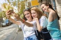 Smiling teenage girls taking a selfie photo outdoors. Royalty Free Stock Photo