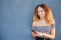 Smiling teenage latina girl holding smart phone using mobile app technology at home. Happy young Hispanic girl texting Royalty Free Stock Photo