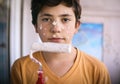 Smiling teenager boy with white paint roller and dirty face make repaint Royalty Free Stock Photo