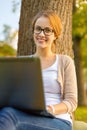 Smiling teenager in eyeglasses with laptop Royalty Free Stock Photo
