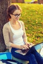 Smiling teenager in eyeglasses with laptop Royalty Free Stock Photo