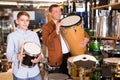 teenager and father deciding on ethnic drum in musical shop