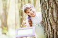 Smiling teenager girl  holding plate for records in a spring garden Royalty Free Stock Photo