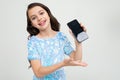 Smiling teenager girl shows a blank phone screen with a mockup on an isolated studio background