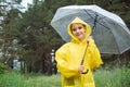 Smiling girl stands against forest holding stylish umbrella Royalty Free Stock Photo