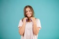 Smiling teenager with long straight brown hair is taking off her blue headphones