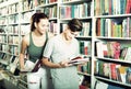 Smiling teenagers holding book and reading together Royalty Free Stock Photo