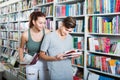 Smiling teenagers holding book and reading together Royalty Free Stock Photo