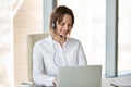 Smiling telemarketer wearing headset consulting customer making