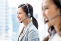 Smiling telemarketing Asian woman in call center