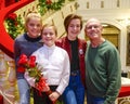 Smiling ten-year-old girl standing on a red stairway with elderly grandfather and sisters Royalty Free Stock Photo