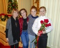 Smiling ten-year-old girl standing on a red stairway with middle-aged mother and sisters Royalty Free Stock Photo