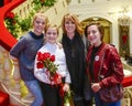 Smiling ten-year-old girl standing on a red stairway with Mother and sisters Royalty Free Stock Photo