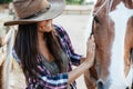 Smiling tender young woman cowgirl in hat with her horse Royalty Free Stock Photo