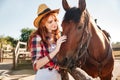 Smiling tender young woman cowgirl with her horse on ranch Royalty Free Stock Photo