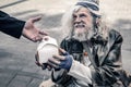 Cheerful long-haired old man living on the street and holding box with food