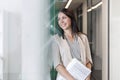 Smiling thoughtful businesswoman with documents at office