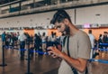 Joyful adult man is waiting for his departure while using mobile phone Royalty Free Stock Photo