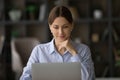 Smiling thoughtful young business lady working on computer. Royalty Free Stock Photo